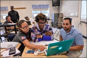 Teachers Jessica Howell (left), Courtney Gray, and Alex Henderson (right) work on physics problems during training at Gateway Regional High School.