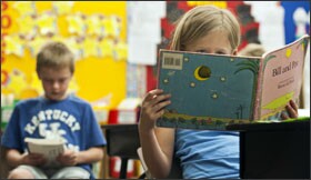 Katie Ebert and Ryan Davis read during teacher Mindy Ball’s class at Arnett Elementary School, where charts track each student’s progress.
