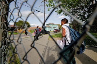 Parents wait for their children after school was dismissed for an extended closure at the Dr. Martin Luther King, Jr. Elementary School for Science and Technology in New Orleans, Friday, March 13, 2020. Louisiana Gov. John Bel Edwards closed K-12 public schools across the state for roughly a month and banned gatherings of more than 250 people in an effort to slow the spread of the coronavirus.