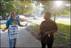 A striking teacher talks to a parent outside Lodge Elementary School, while administrators hold classes.