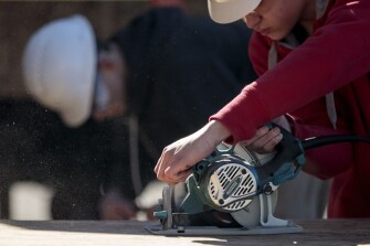 Freshman Quentin Main, 15, cuts a piece of plywood for a tiny house on Friday, March 22, 2019 at Battle High School in Columbia, Mo. Students in a combined construction and geometry class are building a tiny house for a low-income family in the community.