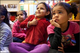 Nicole Ayala, center, gives a thumbs-up to indicate she has the answer to a question posed during the lesson in Ms. Mendez’s classroom.