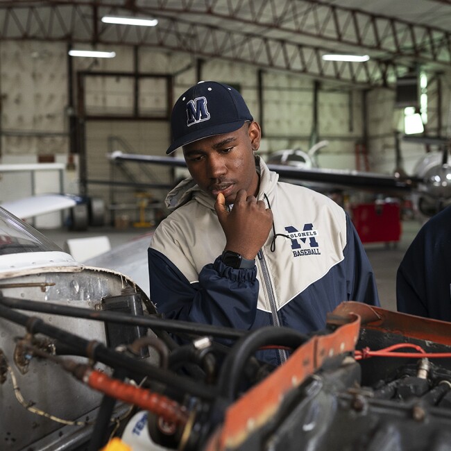 Sophomore Byron Barksdale, part of the aviation program at Magruder High School, takes a look at the exposed engine of a plane during a visit to the Montgomery County Airpark in Gaithersburg, Md., on April 6, 2022.