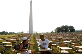 Lisseth Mejia, left, and Manaye Felleke discuss a public installation of 857 empty school desks, representing the number of students nationwide who are dropping out every hour of every school day, on the National Mall in Washington, D.C., on June 20. "Is this really true," asked Ms. Mejia. "The dropout rate is really shocking."
