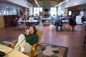 Student Aeriel, 17, who is working towards her high school equivalency diploma, enjoys a light moment as she talks with family on the phone from a common area in a dorm at the Wyoming Girls School.