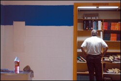 Ron Burchardt, an assistant principal at Bonnabel High School, examines textbooks inside a water-damaged building. He estimates that about 90 percent of the school's books were unscathed, but says many books students took home with them were lost.