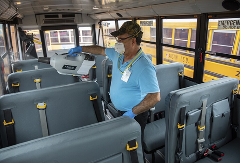Juvenal Landeros applies an antimicrobial coating to the interior of school buses in Austin, Texas. Extra cleaning and safety precautions aboard school buses to guard against coronavirus infection are among the challenges facing school transportation officials as they prepare to reopen for the 2020-21 academic year.