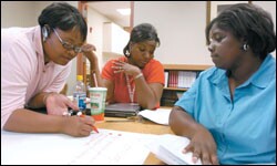 Davita Lancelin, left, Dequindra Redding, and Pamela Jordan work together at an elementary school on a project for their studies at the University of Louisiana at Lafayette.