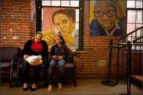 Maria Lopez, left, fills out paperwork at the Family Resource Center to register daughter Arleni Rodriguez for classes in the Lawrence school district last month.