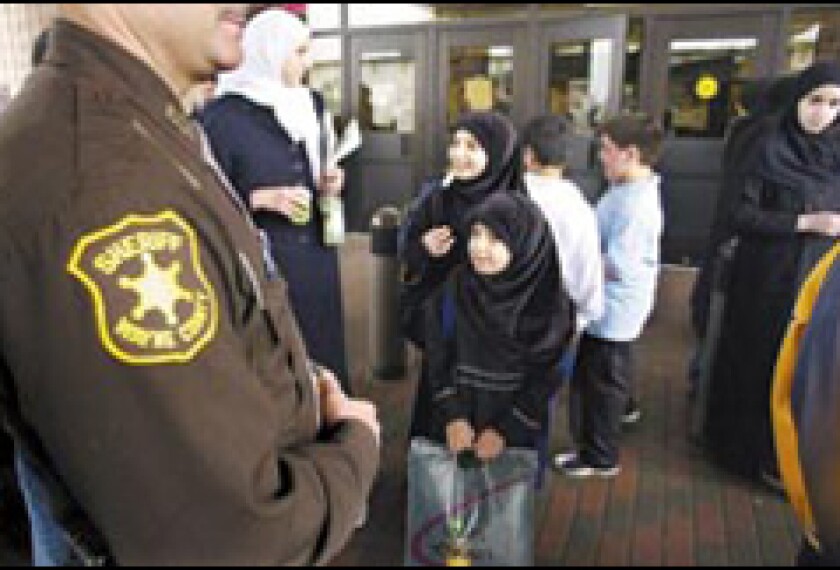 As hostilities begin in Iraq, a Wayne County, Mich., deputy sheriff stands guard March 21 at the Islamic Institute of Knowledge, a private school in Dearborn with many students of Iraqi descent. 