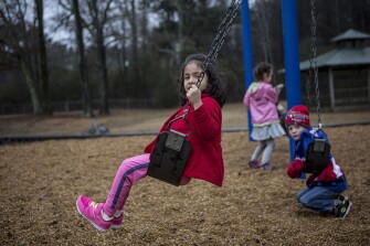 Shameela Dewage plays on the swings with her classmates during recess with their preschool class at Starkville.