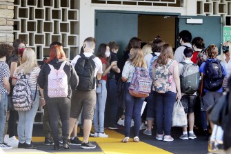 Students enter Gulf Middle School during the first day of school for Pasco County Schools in New Port Richey, Fla., in this Monday, Aug. 24, 2020, photo. Some fear that recent COVID-19 outbreaks tied to summer camps in Florida and other states may be a preview of the upcoming school year.