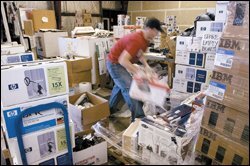 An employee of ECCO Recycles, in Kent, Wash., organizes boxes of printer cartridges the company bought from local schools. ECCO sells the cartridges to outfits that remanufacture them.
