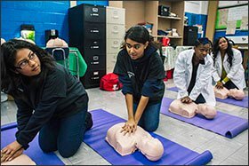 The students and faculty who advise the principal participate in a CPR training class, from left to right: Jessica Román, a senior; April Colon, a senior; Peta-Gaye Williams, assistant principal; and Diamond Joseph, college counselor.