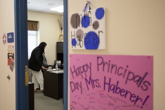 Manuela Haberer, principal of Boone Elementary School, changes from high heels into sandals in her office before heading outside to direct parents and students in the pick-up line at the conclusion of the school day on Thursday, May 19, 2022 in San Antonio, Texas.