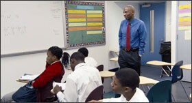Geoffrey Canada, the founder of the Harlem Children’s Zone, looks on as students tackle math problems in one of his charter schools, which have been praised for their efforts to close achievement gaps