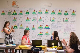 Janna Sells, left, an instructional facilitator at East Iredell Elementary School in Statesville, N.C., celebrates with 2nd grade teachers after discussing data that show that most of 2nd grade students are performing at or above their grade level during a professional learning community meeting at the school.