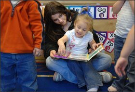 Cassie Fournier, 17, a senior at Franklin High School in Franklin, N.H., reads to Haven Nadeau, 4, at the school’s day-care center. Under the state’s Extended Learning Opportunity pilot program for high school students, Ms. Fournier is earning credit in child development and child psychology for the time she spends working with the children.