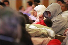 Two women shield themselves during a press conference in Postville, Iowa, where school officials spent much of last week working to reassure immigrant families after hundreds of arrests at a local meat-processing plant.