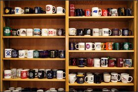 Mugs from various colleges and universities occupy the shelves in Principal Carol Burris' office at South Side High School. Former students make a point to stop by for a visit and contribute to the collection.