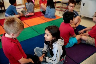 Parker Davis, left, and Alina Lopez talk about words and acts that cause happiness during Morning Circle in teacher Susannah Young 2nd grade class at Lincoln Elementary School in Oakland, Calif. in May 2017.