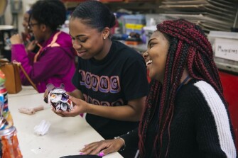 Rochelle laughs at her partner, senior Janell Nocentelli, during sculpture class. They made a lotus flower out of found objects for an assemblage project.