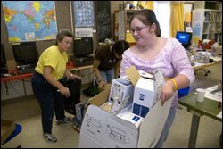 Sarah Agan, right, a 7th grader at Seattle's Whitman Middle School, and her teacher, Rebecca M. Cline, move boxes of used printer cartridges to sell to companies that refurbish and refill them.