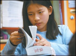 6th grader Rachael Brickson refers to her English-Chinese dictionary to find a word for the class.