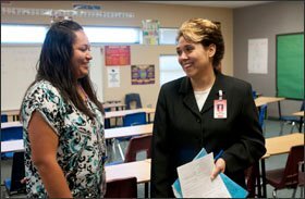 At left, Lynda Espino, 24, another teacher-candidate at ASU, talks with Teena Lugo-Flesher, the college’s coordinator for the Littleton school district, after leading an 8th grade math class at Collier Elementary School in Avondale last week. University faculty members work on site with student-teachers.