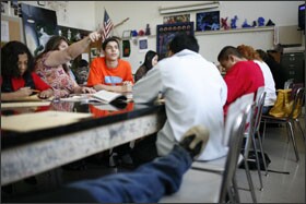 Teacher Jen McCoy helps Faris Musa, 17, an Iraqi immigrant, in orange, in art class at East High School.