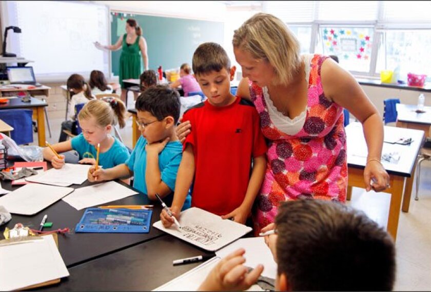 Special educator Katierose Dobrzykowski, right, checks in with a student while co-teaching 3rd grade math with general educator Sara Dunaway at Norwood Elementary School in Baltimore, Md.