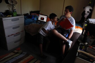 Alexander Gonzalez, 8, left, talks to his brother Jairo, 11, about a homework assignment in the bedroom they share in their home in Foley, Ala. Alexander is in 2nd grade at Foley Elementary School and Jairo is in 6th grade at Foley Intermediate School. Jairo was working on questions about the book Tuck Everlasting. One question stumped him. It asked where he thought he would be in ten years. Alexander suggested a soccer star or musician. Jairo wasn't able to imagine his future.