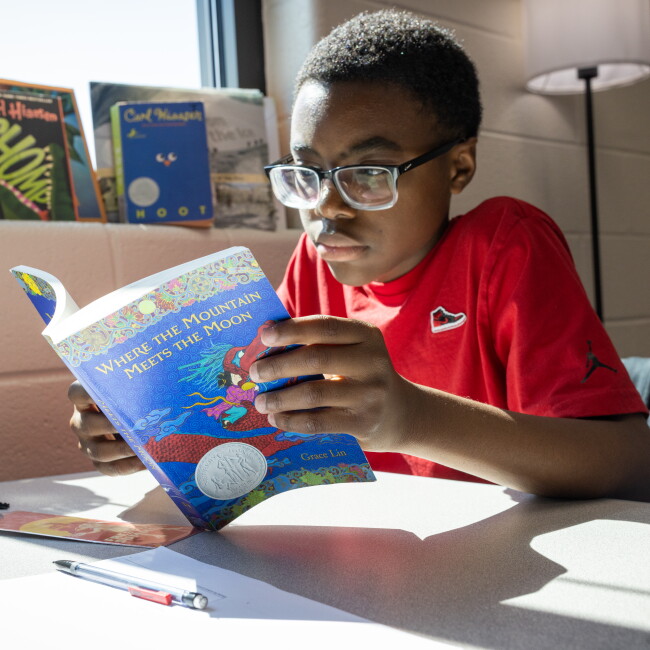 A student reads from his copy of Where the Mountain Meets the Moon at Murphy Middle School in Dacula, Ga., in teacher Jaime Johnson's 6th grade class. Johnson has students read together in class as part of an effort to ensure they complete texts and, hopefully, get hooked on the power of books.