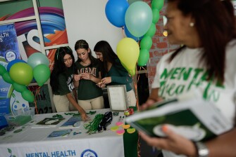 Members of the Miami Arts Studio mental health club, including from left, Salet Aquino, Dominique Rodriguez, and club president Anaeli Souto, man a table as they raise awareness on World Mental Health Day, Oct. 10, 2023, at Miami Arts Studio, a public 6th-12th grade magnet school, in Miami.