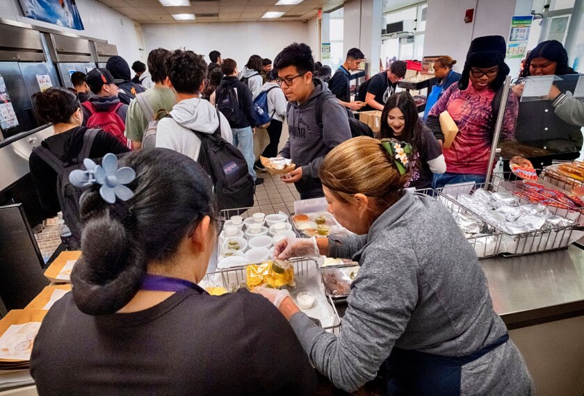 Cafeteria workers serve student lunches at Firebaugh High School in Lynwood, Calif. on Wednesday, April 3, 2024. Demand for school lunches has increased after California guaranteed free meals to all students regardless of their family's income.