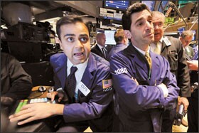 Specialist Dilip Patel, left, works at his post at the New York Stock Exchange on Oct. 29. Pension plans have been stung by falling stock values.