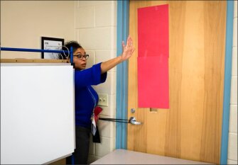 Helena Wolfe-Wilder, a 5th grade teacher at Forest Hills Community Learning Center, instructs her students to keep still while she secures a door. The Akron, Ohio, school recently organized a drill to prepare students and staff for how to respond to a gunman on campus.