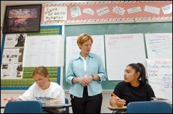 Lori Pfeifer, an English teacher at Iroquois High, center, helps Debbie Elmore, left, and Veronica Antonio organize their thoughts for a writing assignment.