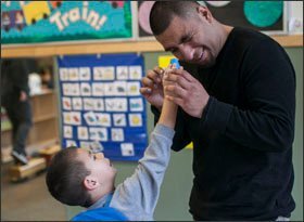 Diego Ramirez, 4, holds a kaleidoscope for his father, Wences Ramirez, in the boy's classroom at Childhaven, a therapeutic day-care center in Seattle. Childhaven is teaching parents and children to play games together to build the children's focus and self-control. The program is part of a larger statewide effort to improve learning and well-being.