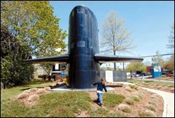 A child plays near a portion of the USS George Washington at a submarine museum in Groton, Conn. That city's U.S. naval submarine base will close if a Pentagon recommendation is followed.