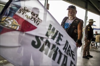 Steven Littleton Jr. extends a flag that honors the victims of the Santa Fe High School shooting.
