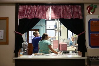 Pat Dickerson, left, talks to Tami Langley at Ansted Elementary in Fayette County. The cooks said they have to cover all their food and cooking utensils with plastic bags before they leave at night because coal dust from the furnace settles in the kitchen.