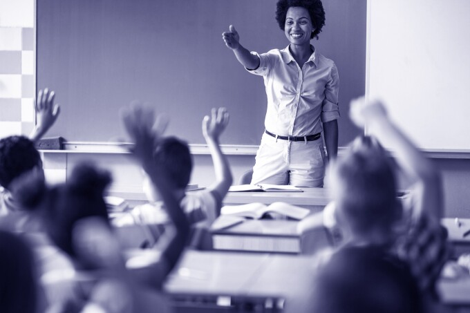 Image shows a teacher in a classroom.