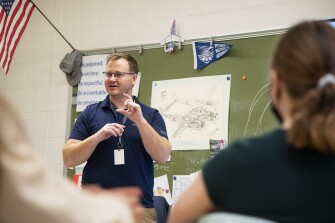 Dan Howell, aviation and technology teacher at Magruder High School in Rockville, Md., gives a lesson on batteries as part of the aviation curriculum on April 7, 2022.