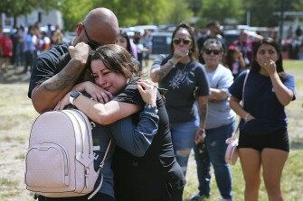 A family shares a tearful reunion following a chaotic scene outside of Thomas Jefferson High School in San Antonio, after the school went into lockdown on Tuesday, Sept. 20, 2022. Alarmed parents laid siege to the Texas high school Tuesday after a classroom shooting report that ultimately proved to be false.