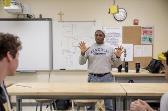 Carl Dement, woodworking and construction teacher, speaks to students at the beginning of class on Friday, March 22, 2019 at Battle High School in Columbia, Mo. Students in a combined construction and geometry class are building a tiny house for a low-income family in the community.