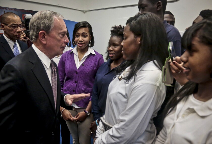 New York's Mayor Michael Bloomberg, second from left, and Schools Chancellor Dennis Walcott, far left, meeting with senior students at the Bedford Academy High School in New York on Dec. 3, 2013. Bloomberg campaigned on gaining control of the nation's largest public school system. left his mark by championing charter schools, expanding school choice, giving schools letter grades, and replacing scores of struggling institutions with clusters of small schools.