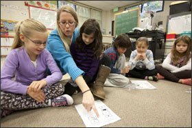 Katie Wright-Sabbatino guides 2nd graders Isabella Brown, left, and Samantha Jolson during a lesson on photosynthesis. The Fort Garrison Elementary School is experimenting with combining science and dance.