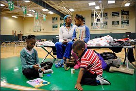 Roslyn Pitt and three of her 10 children settle in at an American Red Cross shelter at Locust Valley High School in Long Island after being evacuated from their home in Glen Cove, N.Y. With Ms. Pitt are her children Niyah, 8, left; Sharah, 5; and Gamar, 4. Schools that weren't flooded or damaged in the storm were turned into temporary emergency shelters in several Mid-Atlantic states.