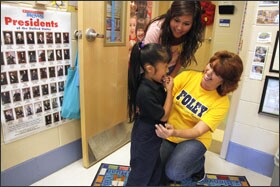 Lucy Cunningham, right, an ESL paraeducator at Foley Elementary, helps kindergartner Lizabeth Guerra try on pants to replace the oversized pair she wore to school while volunteer Dora Gutierrez looks on. Foley's staff collects food and clothing for needy families, teaches adult ESL classes, and helps families translate documents.